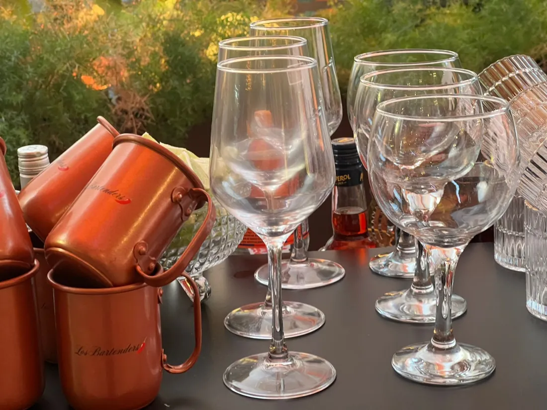 Canecas de cobre com a marca Los Bartenders e taças de vidro